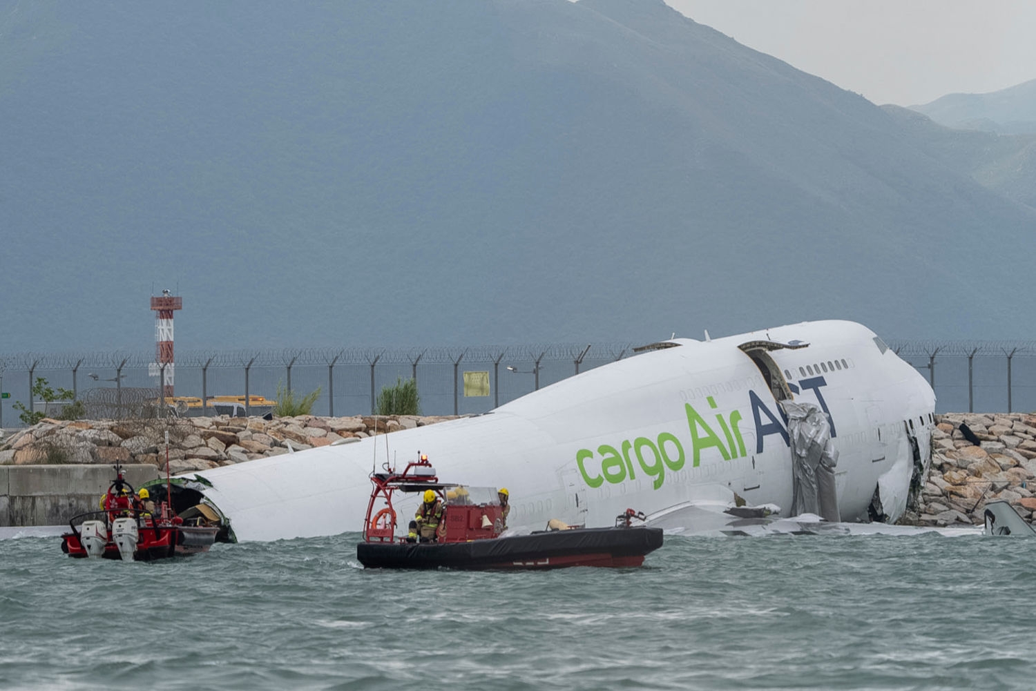 Redningsmannskaper ved flyet som skled av rullebanen i Hongkong.